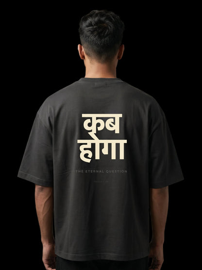 Person wearing a black t-shirt with white text on the back against a gray background